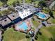 Aerial view of resort-style amenities, including pools, clubhouse, and manicured grounds surrounded by lush greenery at 9144 Bassett Ln, New Port Richey, FL 34655