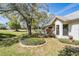 A cozy backyard view features an expansive green yard, a decorative brick-lined garden, and mature trees at 9144 Bassett Ln, New Port Richey, FL 34655