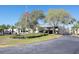 Inviting clubhouse with lush landscaping, mature trees, and an American flag waving proudly on a clear day at 9144 Bassett Ln, New Port Richey, FL 34655