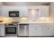 Modern kitchen featuring stainless steel appliances, white cabinets and backsplash, and under cabinet lighting at 9144 Bassett Ln, New Port Richey, FL 34655