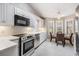 Bright kitchen showcasing stainless steel appliances, white cabinetry, subway tile backsplash and breakfast nook with natural light at 9144 Bassett Ln, New Port Richey, FL 34655