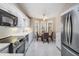 Modern kitchen featuring stainless steel appliances, white cabinets, tile flooring, and an adjacent breakfast nook at 9144 Bassett Ln, New Port Richey, FL 34655