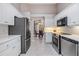 Modern kitchen with stainless steel appliances, white cabinets, and an adjacent dining area with a chandelier at 9144 Bassett Ln, New Port Richey, FL 34655