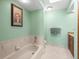 Well-lit bathroom with tile flooring and a soaking tub, perfect for relaxation at 9630 Southern Belle Dr, Weeki Wachee, FL 34613