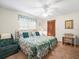 Inviting bedroom featuring twin beds, a cozy armchair, and a bright window at 9630 Southern Belle Dr, Weeki Wachee, FL 34613
