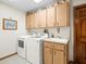 Well-equipped laundry room with washer, dryer, sink, and cabinets providing ample storage space at 9630 Southern Belle Dr, Weeki Wachee, FL 34613