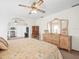 Inviting bedroom featuring a floral bedspread, ceiling fan, and decorative dresser at 9630 Southern Belle Dr, Weeki Wachee, FL 34613