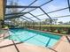 Sparkling screened-in pool with brick coping, set amidst manicured landscaping and bathed in sunlight at 9630 Southern Belle Dr, Weeki Wachee, FL 34613