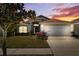 Charming single-story home with a well-maintained lawn and a two-car garage, enhanced by a picturesque sunset backdrop at 11023 Silver Dancer Dr, Riverview, FL 33579