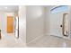 Bright foyer featuring neutral tiled flooring, front door and view into the kitchen at 11023 Silver Dancer Dr, Riverview, FL 33579