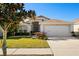 Charming single-story home featuring a well-manicured lawn, beautiful landscaping, and a two-car garage at 11023 Silver Dancer Dr, Riverview, FL 33579