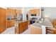 Well-equipped kitchen with stainless steel appliances, wooden cabinetry, and a granite-topped island at 11023 Silver Dancer Dr, Riverview, FL 33579