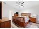 Bright bedroom features wood-look floors, a ceiling fan, and traditional wood furniture, creating a cozy retreat at 11023 Silver Dancer Dr, Riverview, FL 33579