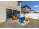 Cozy backyard patio with colorful chairs surrounding a fire pit, perfect for outdoor entertaining at 11895 Crestridge Loop, New Port Richey, FL 34655