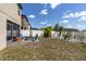 Inviting backyard with a fire pit area, screened lanai, palm trees, and a white fence for added privacy at 11895 Crestridge Loop, New Port Richey, FL 34655