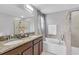 Elegant bathroom with double sinks, granite countertops, and separate tub and shower at 11895 Crestridge Loop, New Port Richey, FL 34655