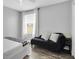 Bright bedroom featuring a large window and a black futon with decorative pillows at 11895 Crestridge Loop, New Port Richey, FL 34655