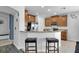 Kitchen featuring a breakfast bar with granite countertops, stainless appliances, and brown cabinetry at 11895 Crestridge Loop, New Port Richey, FL 34655