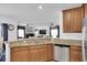 Open kitchen layout with granite countertops, stainless appliances, and hardwood cabinets overlooking the living area at 11895 Crestridge Loop, New Port Richey, FL 34655