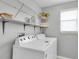 Well-lit laundry room with modern washer and dryer and convenient overhead shelving at 11895 Crestridge Loop, New Port Richey, FL 34655