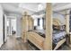 View of spacious main bedroom with four-poster bed and a glimpse into the connected bathroom at 11895 Crestridge Loop, New Port Richey, FL 34655