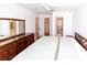 Bedroom with a large wooden dresser, neutral decor, and access to bath and closet at 1223 Queen Anne Dr # B, Palm Harbor, FL 34684