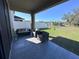 Covered patio featuring stone tile, cushioned furniture, and a tranquil backyard view at 12403 Coralbean Ct, New Port Richey, FL 34654
