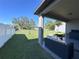 Outdoor patio with wicker furniture overlooks a spacious backyard with green grass at 12403 Coralbean Ct, New Port Richey, FL 34654