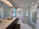 Modern bathroom featuring a double vanity, glass shower, and stylish tile work at 12403 Coralbean Ct, New Port Richey, FL 34654