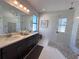 Elegant bathroom with double sinks, a glass shower, and sophisticated finishes at 12403 Coralbean Ct, New Port Richey, FL 34654