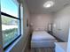 Bedroom featuring wood-look flooring, modern accents, and a bright window at 12403 Coralbean Ct, New Port Richey, FL 34654