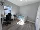 Bright bedroom features a twin bed, desk, wood floors, and plenty of natural light at 12403 Coralbean Ct, New Port Richey, FL 34654