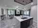 Kitchen island with pendant lighting, stainless steel appliances, and open layout to dining and living areas at 12403 Coralbean Ct, New Port Richey, FL 34654