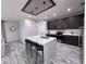 Modern kitchen with a large marble island, dark cabinets, and pendant lighting at 12403 Coralbean Ct, New Port Richey, FL 34654
