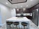 Modern kitchen with quartz island, pendant lighting, stainless steel appliances, and dark wood cabinets at 12403 Coralbean Ct, New Port Richey, FL 34654