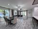 Spacious living room with wood-look tile floors, fan, and dining table with fruit centerpiece at 12403 Coralbean Ct, New Port Richey, FL 34654
