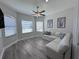 Bright living room features modern ceiling fan, beautiful plank flooring, and large windows at 12403 Coralbean Ct, New Port Richey, FL 34654