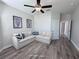 Living room with neutral walls, plank flooring, ceiling fan, and decorative wall art at 12403 Coralbean Ct, New Port Richey, FL 34654