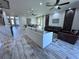 Open-concept living room with wood-look tile, multiple couches, and decorative wall accents at 12403 Coralbean Ct, New Port Richey, FL 34654