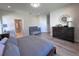 Bright bedroom with laminate flooring, dresser, and modern decor elements at 12403 Coralbean Ct, New Port Richey, FL 34654