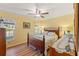 Inviting bedroom featuring wood floors, a decorative ceiling fan, and natural light from the windows at 1281 Bolander Ave, Spring Hill, FL 34609