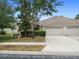 Charming home featuring a three-car garage, well-maintained landscaping, and a paved driveway at 13043 Moonstone Way, Spring Hill, FL 34609