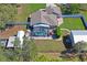An aerial view of a fenced backyard, featuring a pool, a garage, and green space at 13045 Marbled Godwit Rd, Weeki Wachee, FL 34614