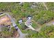 Bird's eye view of a house surrounded by lush trees, a detached shed, and neighboring homes in the distance at 13045 Marbled Godwit Rd, Weeki Wachee, FL 34614