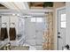 Bright bathroom featuring a shower with glass doors and a decorative patterned curtain at 13045 Marbled Godwit Rd, Weeki Wachee, FL 34614
