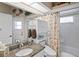Charming bathroom with granite countertop, shower with patterned curtain and tile walls at 13045 Marbled Godwit Rd, Weeki Wachee, FL 34614