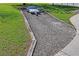 Gravel driveway on a well-maintained grassy yard shows space for additional parking for vehicles or storage at 13045 Marbled Godwit Rd, Weeki Wachee, FL 34614