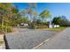 View of exterior fenced area with gravel, buildings and driveway at 13045 Marbled Godwit Rd, Weeki Wachee, FL 34614