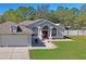 Beautiful home with a garage, manicured lawn, brick patio and lush landscaping at 13045 Marbled Godwit Rd, Weeki Wachee, FL 34614
