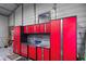 Garage interior with ample storage featuring stainless steel countertops and red cabinets at 13045 Marbled Godwit Rd, Weeki Wachee, FL 34614